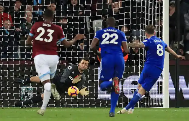 West Ham United goalkeeper Lukasz Fabianski makes a save from a penalty taken by Cardiff City’s Joe Ralls, right, during their English Premier League soccer match.