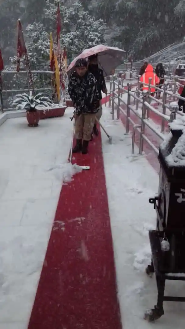 A security personnel tries to move the snow off the path to the temple in Katra. 
