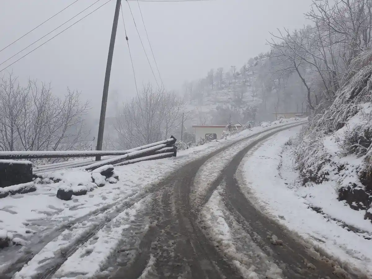 Tire marks on the road covered in snow.