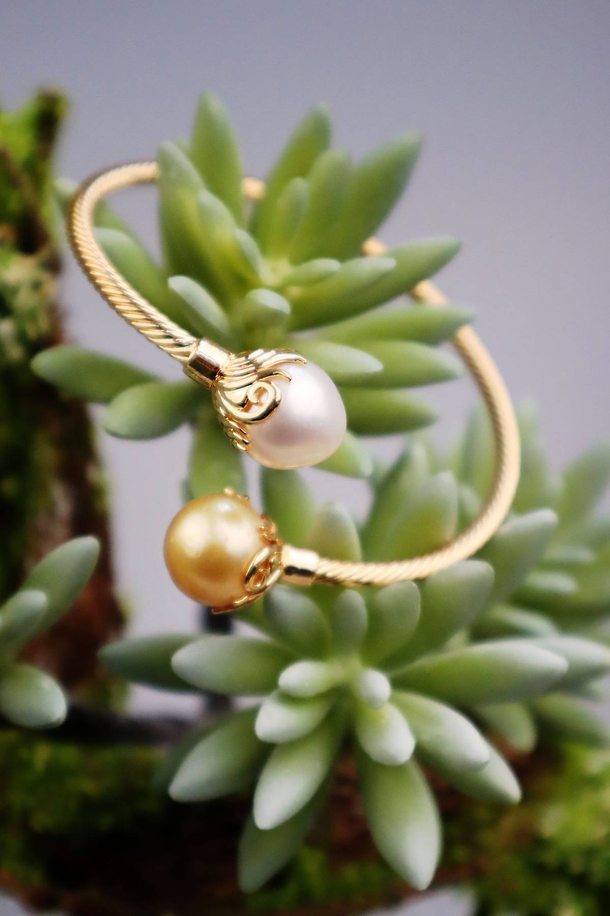 Playful cable bangle with white and champagne South Sea pearls.