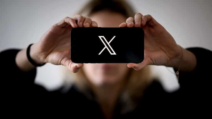 FILE: A woman holds a smartphone displaying the logo of US social network X (former Twitter), in Nantes, western France, on 29 November 2023.