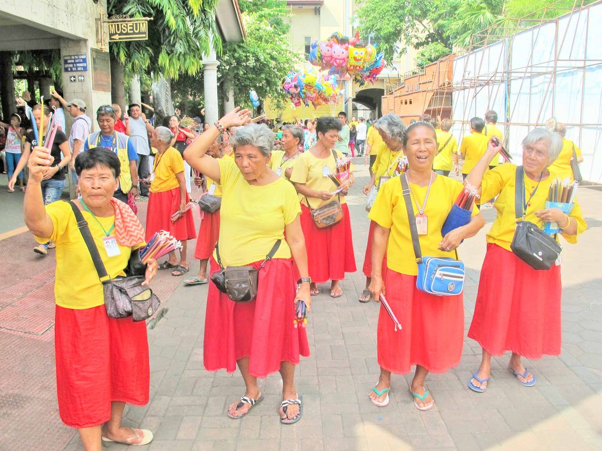 The women at the church pray and dance to El Señor Santo Niño De Cebu for devotees. The worship dance of devotees during processions, called sinulog, is the inspiration of the recently created and touristic Sinulog Festival.