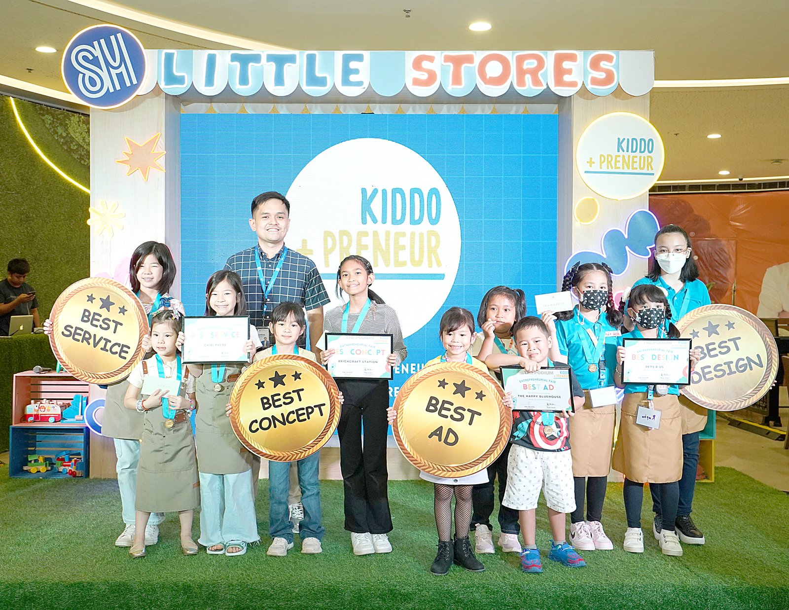 The Podium Assistant Mall Manager Anthony Ryan Sales joins the young entrepreneur winners in displaying their awards for Best Service, Best Concept, Best Ad, and Best Design.