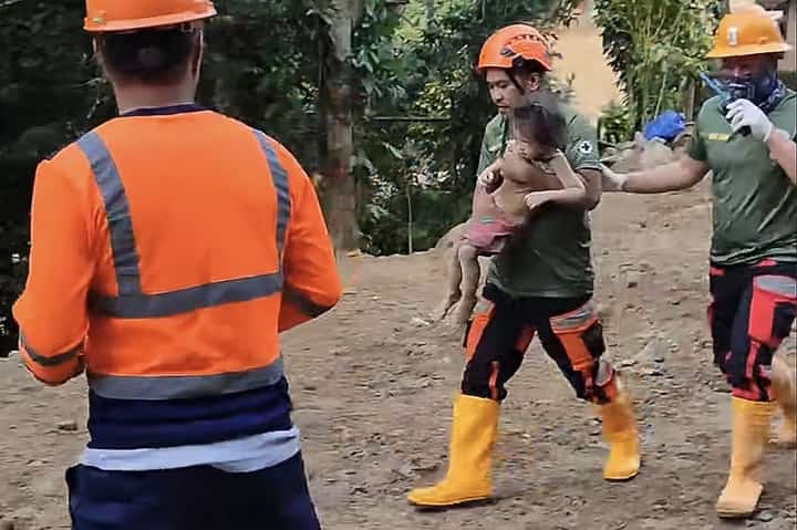 This screengrab from UGC video footage taken on February 9, 2024 and posted by Facebook user Illu Mi shows rescue and emergency personnel carrying a girl found after a nearly 60 hours rescue operation following a landslide that hit a gold-mining village in Maco, Davao de Oro, in southern Philippines. The rescue has been hailed as a "miracle" after searchers had given up hope of finding more survivors. The girl, who the Philippine Red Cross said was three years old, had been among the more than 100 people missing after the rain-induced landslide hit the village, killing at least 15 people.