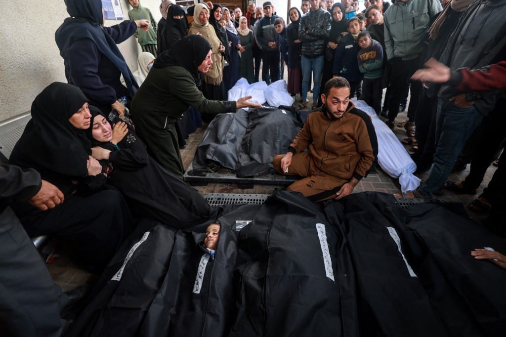 Palestinians mourn by the bodies of relatives who were killed in overnight Israeli air strikes on the Rafah refugee camp in the southern Gaza Strip, at Rafah's Najjar hospital on February 27, 2024, as battles between Israel and the Palestinian militant group Hamas continue.