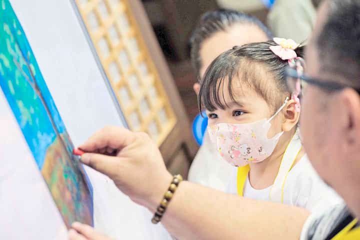 Artist Janet Ballacer gladly shares the oil pastels with a young cancer patient during a unique event of the Manila Clock Tower Museum dubbed ‘Art Therapy for Kids Battling Cancer’ at the museum in Manila City Hall. This event provided art therapy to at least 30 pediatric cancer patients from Philippine General Hospital and National Children’s Hospital.