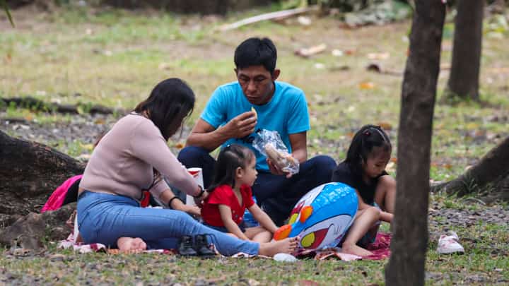 FILES: Families often have a picnic beneath the shade of trees at Luneta Park.