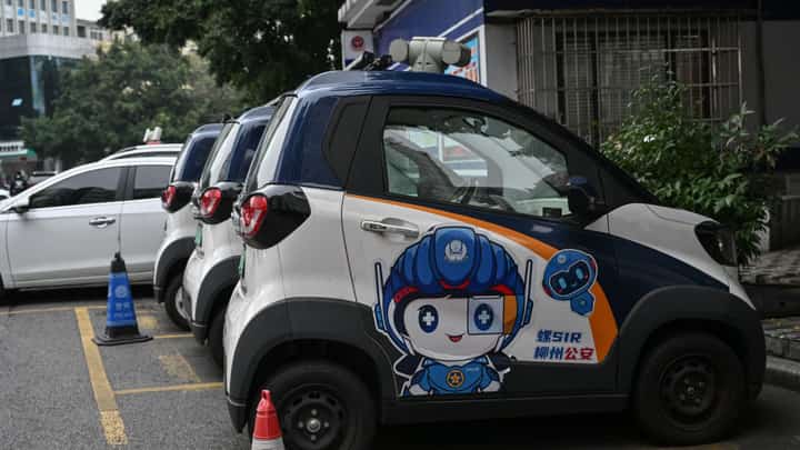 MINI electric cars are parked outside a police station in Liuzhou, in southern China’s Guangxi province. Tiny electric cars weave through traffic, their cheap and cheerful designs bringing a touch of color to the EV revolution in the country’s overlooked cities.