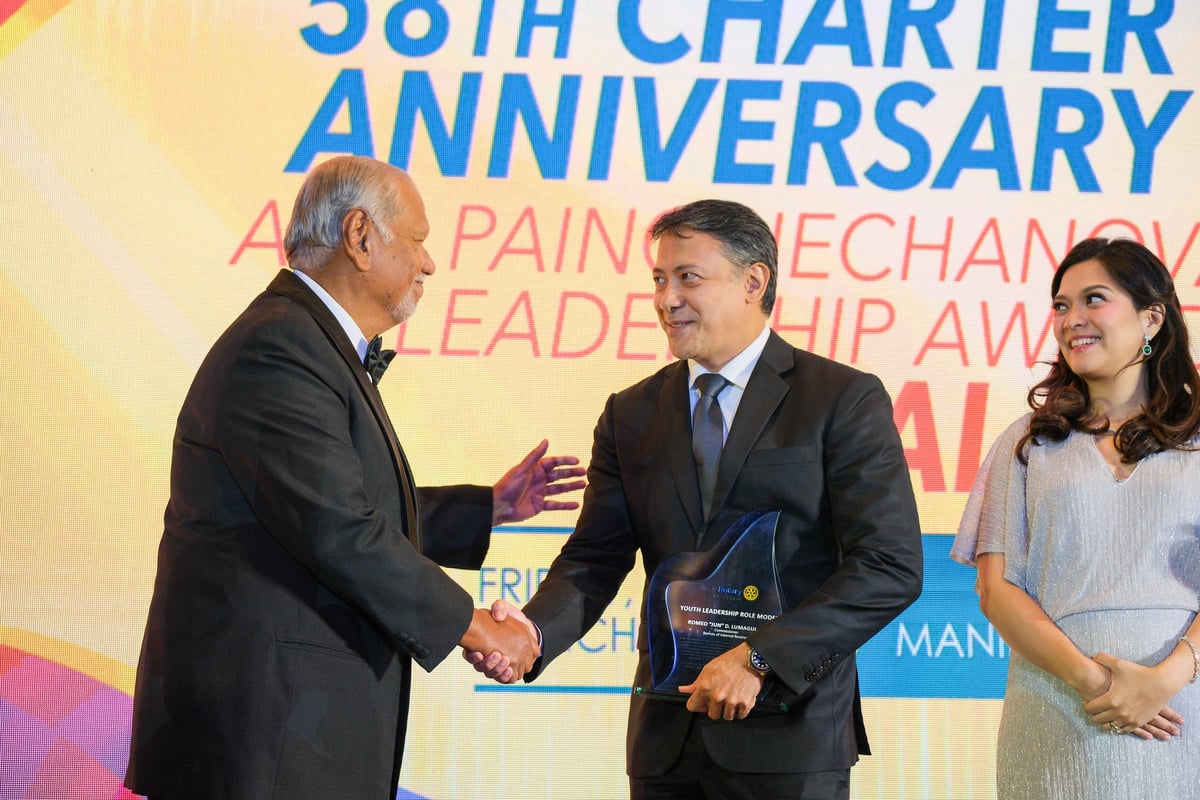 RC Makati president Bing Matoto congratulates Bureau of Internal Revenue Commissioner, RC Makati member and tax lawyer Romeo ‘Jun’ Lumagui Jr., recipient of the Club's  Youth Leadership Role Model award, as his proud, beaming wife, lawyer Carmela Esquivas Lumagui looks on.