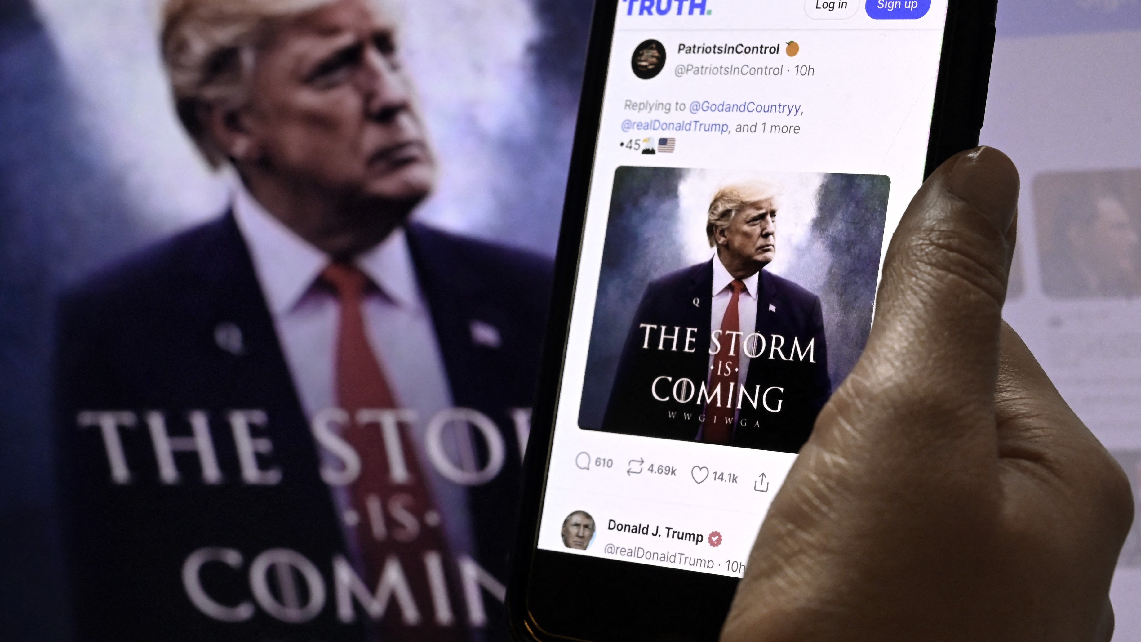 (FILES) In this photo illustration, Donald Trump's TRUTH Social account is seen on a mobile device with an image of former US president Donald Trump in the background in Washington, DC on 13 September 2022.