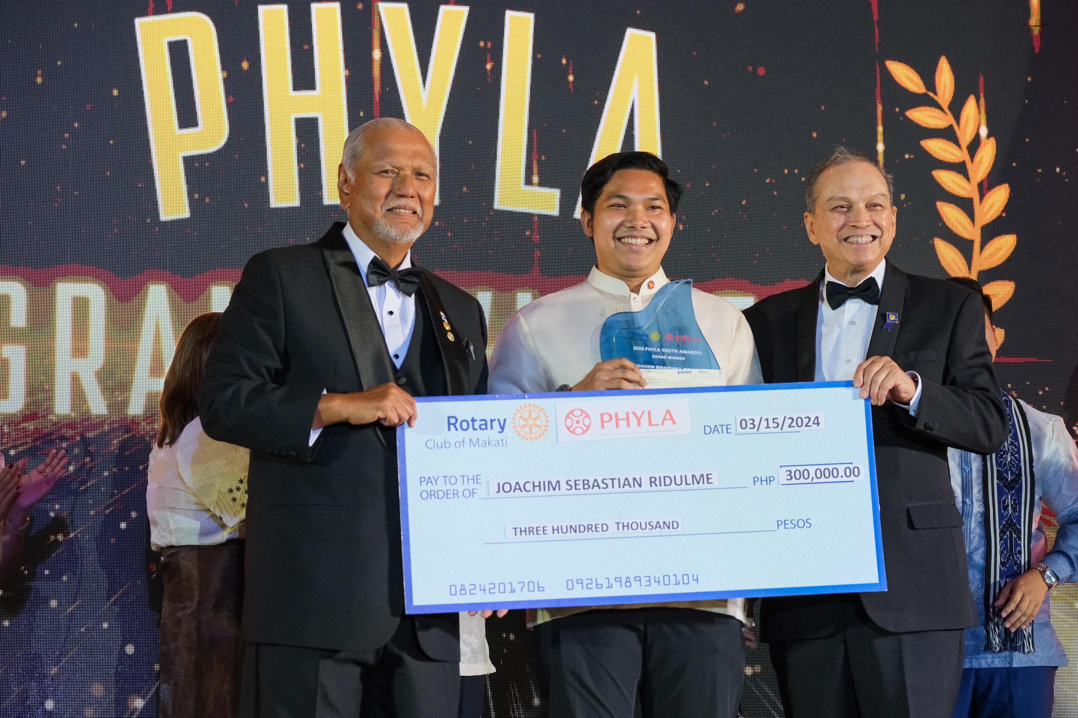 RC Makati President Bing Matoto (left) and PHYLA Chairman and PDG Sid Garcia (3rd from left) pose with PHYLA Grand Winner Joachim Sebastian Ridulme with a presentation cheque representing Ridulme's P300,000 top cash prize.