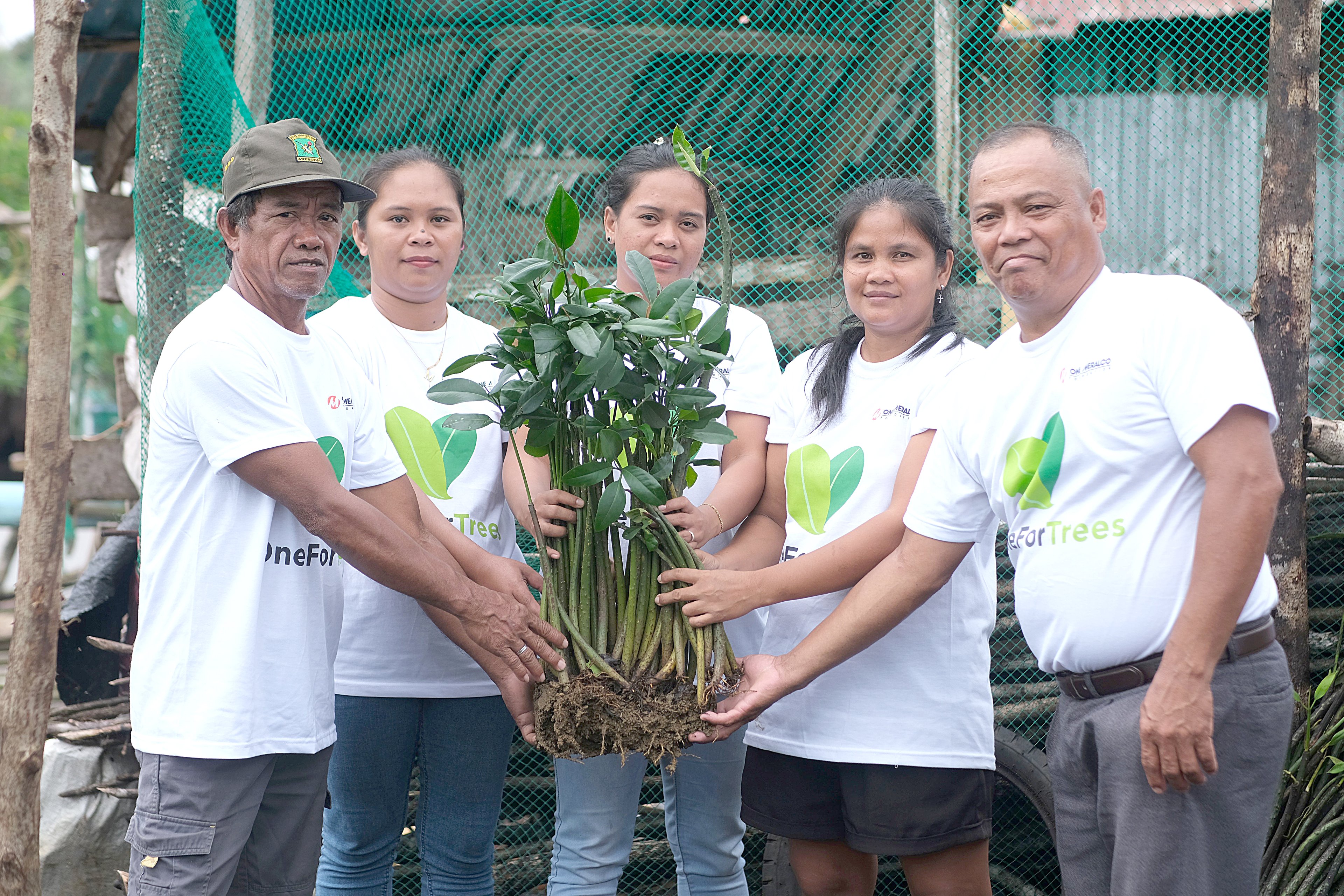 Members of KAMAMANA hold mangrove propagules in the mangrove nursery in Del Carmen, Siargao.