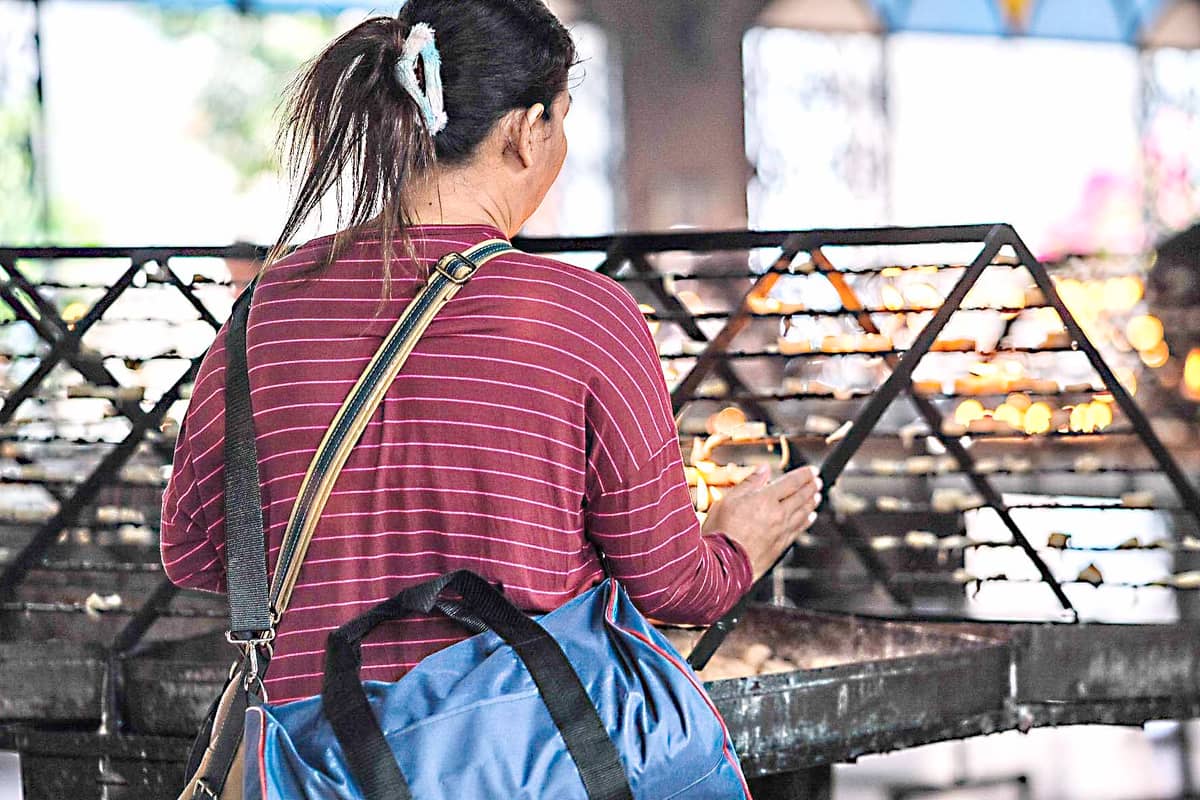 A woman devotee lights a candle at Baclaran church in Parañaque City on Saturday. The soft glow of flickering candles illuminate the air with prayers and reverence.
