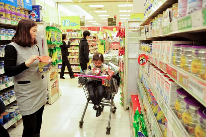 (FILES) A Chinese customer selects milk powder at a supermarket in Qingdao, east China's Shandong province on 14 February 2017.