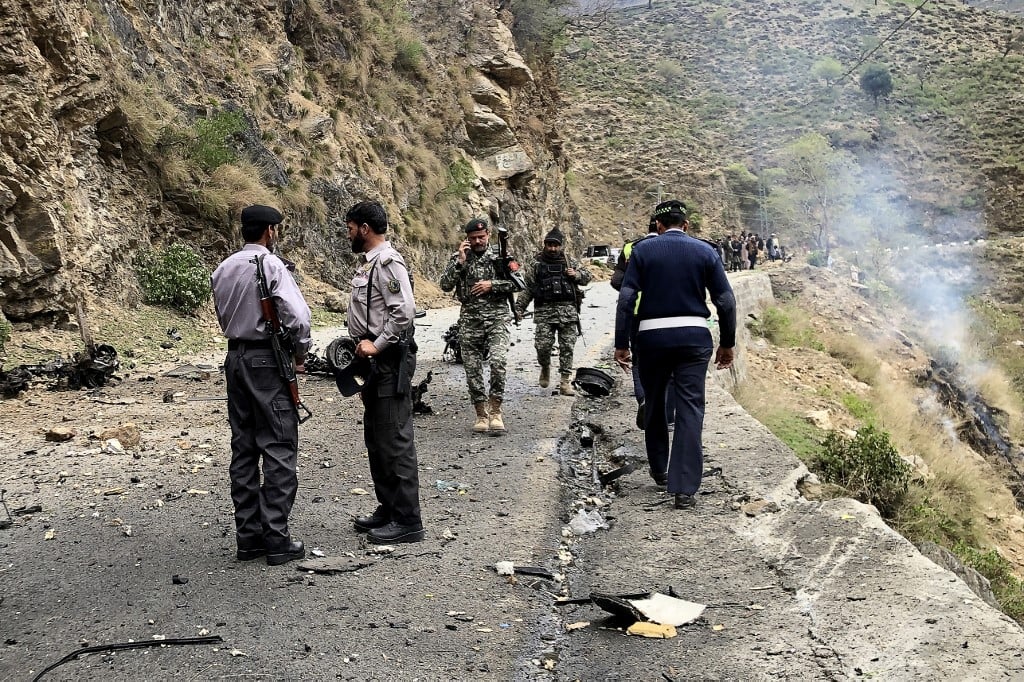 Security personnel inspect the site of a suicide attack near Besham City in the Shangla district of Khyber Pakhtunkhwa province on 26 March  2024. Five Chinese nationals working on a major dam construction site were killed along with their driver on 26 March when a suicide bomber targeted their vehicle in northwest Pakistan, officials said.