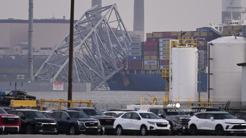 Part of the steel frame of the Francis Scott Key Bridge sits on top of the container ship Dali after the bridge collapsed in Baltimore, Maryland, on 26 March 2024. The bridge collapsed early 26 March after being struck by the Singapore-flagged Dali container ship, sending multiple vehicles and people plunging into the frigid harbor below. There was no immediate confirmation of the cause of the disaster, but Baltimore's Police Commissioner Richard Worley said there was "no indication" of terrorism.