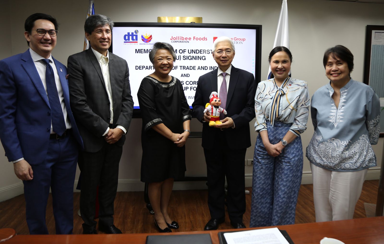 At the agreement signing are (from left) Jollibee Foods Corp. assistant vice president for public affairs Steve Piczon; vice president for public affairs Raul Academia, Jollibee Group Foundation president Ma. Gisela Tiongson, Trade and Industry Secretary Fred Pascual, Undersecretary Ma. Cristina Roque and Bureau of Market Development, Promotion and One Town One Product director Marievic Bonoan.
