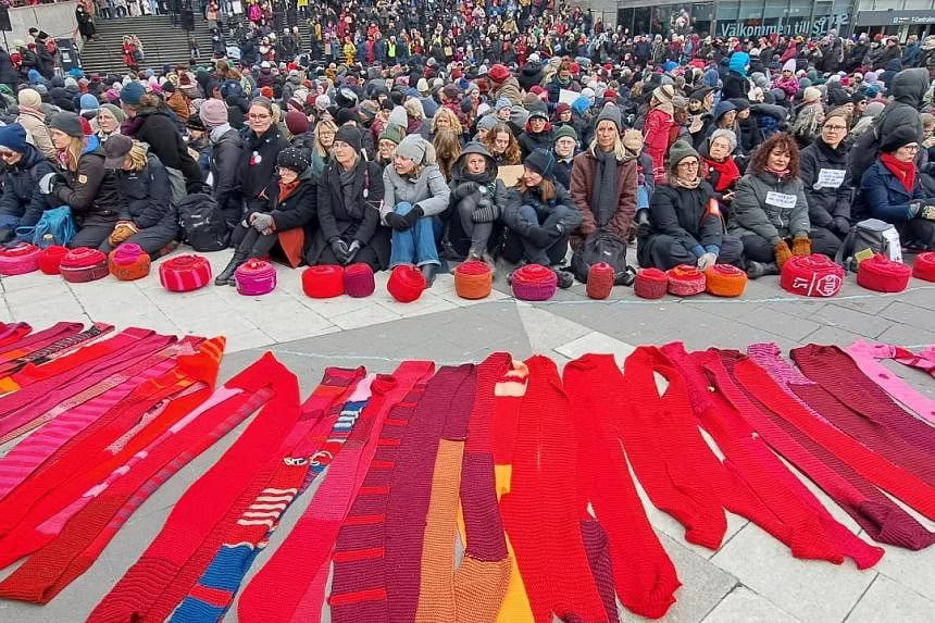 Climate protesters wrap Swedish parliament in giant red scarf