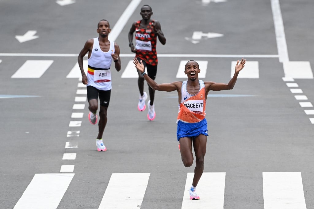 (FILES) Netherlands' Abdi Nageeye (R) reacts as he runs to the finish line in second place ahead of third-placed Belgium's Bashir Abdi (L) and fourth-placed Kenya's Lawrence Cherono (C) in the men's marathon final during the Tokyo 2020 Olympic Games in Sapporo on 8 August 2021.