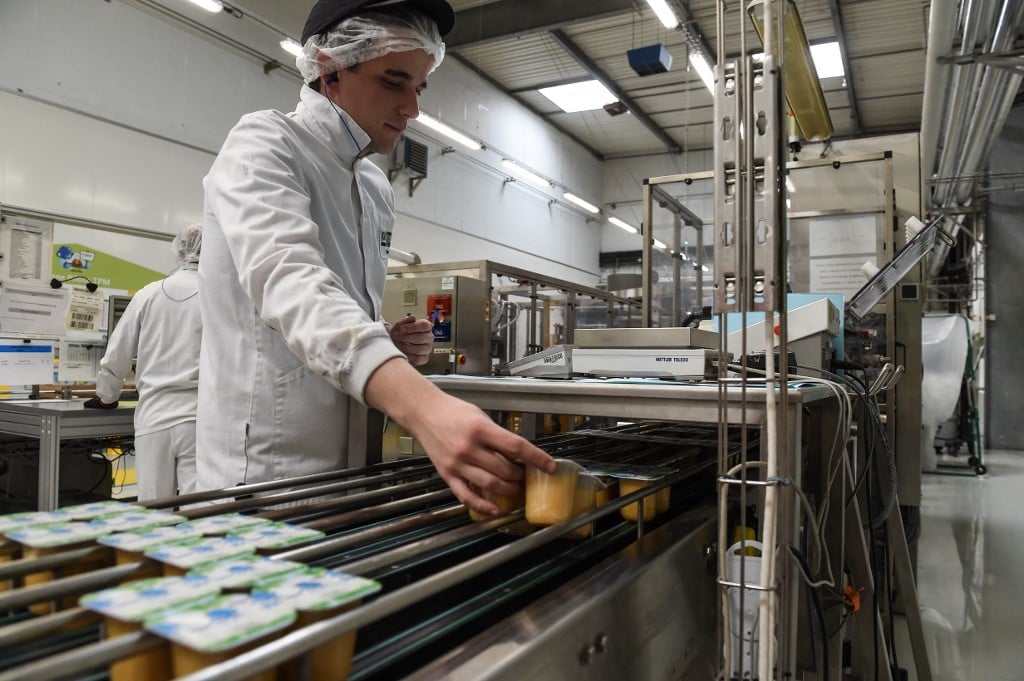 (FILES) An employee selects apples on the production line at the Nestle baby food production plant in Arches (eastern France) on 11 May 2017.