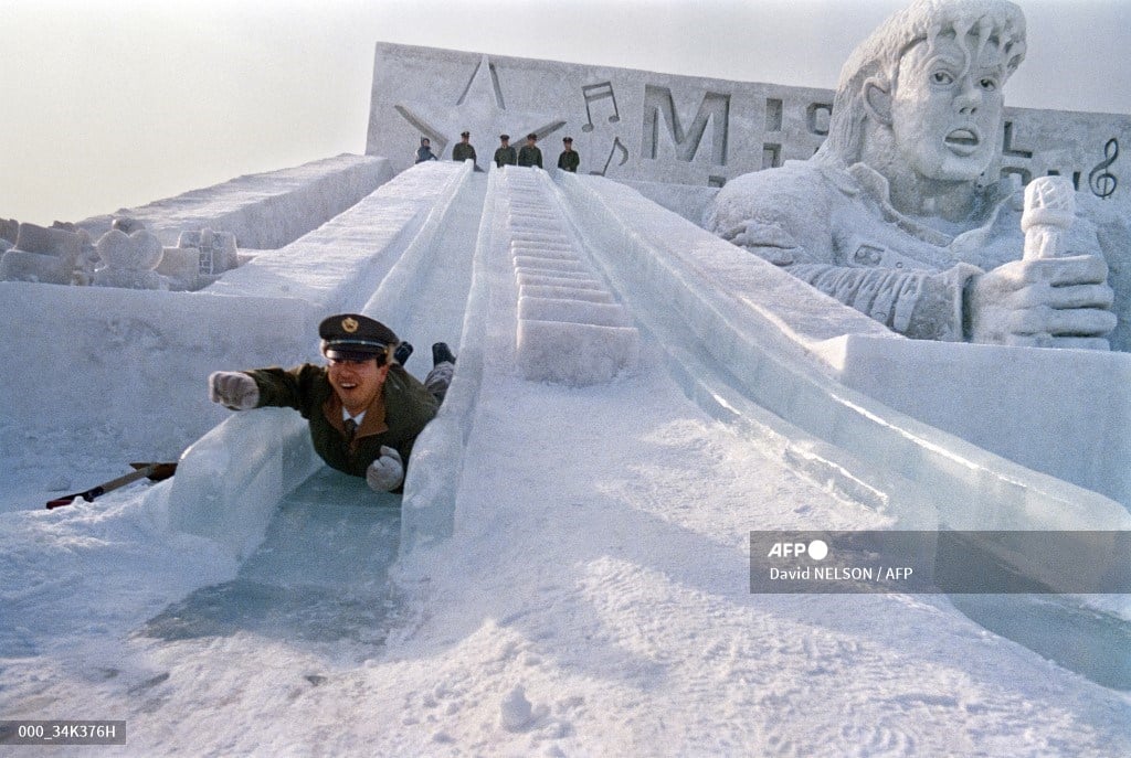 A member of the Japan Self-Defense Forces tests long slides made of blocks of ice right next to a gigantic snow sculpture of American rock star Michael Jackson in a park in Sapporo, 5 February 1988 before the opening of the 39th Sapporo Snow Festival. 

These sculptures are located at the Makomanai festival site, installed at the Ground Self-Defense Forces military base. 

Soldiers of the Self-Defense Forces help build the snow sculptures. 

134 snow sculptures were displayed around the city during the week-long festival, which has taken place annually since 1950. 

It is one of the largest winter events in Japan, bringing together around 2 million visitors each year.