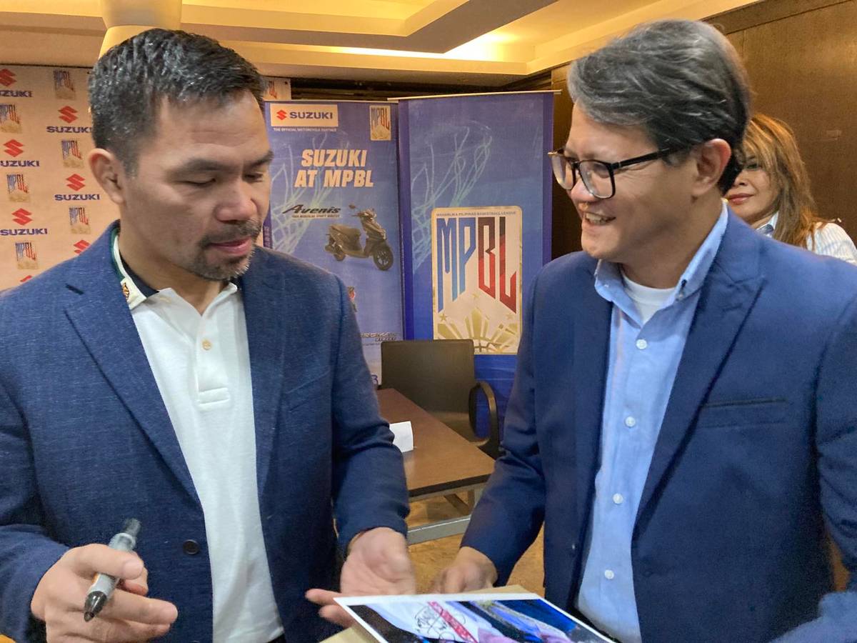 Boxing star Manny Pacquiao signs an autograph of his photo with former WBC flyweight champion Erbito Salavarria, whose son Jose Salavarria (right) is the chief of Suzuki Philippines’ motorcycle division during the contract signing between the MPBL and the Japanese company.