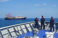(FILES) Philippine Coast Guard crew members aboard the BRP Cabra monitor a Chinese vessel anchored at Sabina Shoal, a West Philippine Sea outcrop located about 135 kilometers west of Palawan. China’s ‘aggressive’ actions in the WPS have earned condemnation from the Philippines and such countries as the United States, Japan, and Australia.