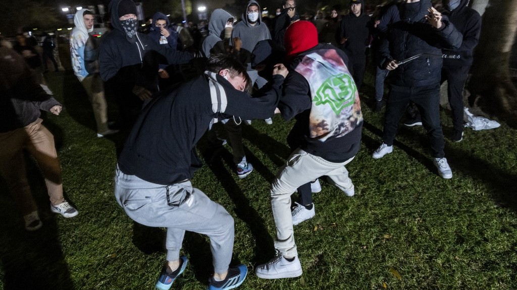 A pro-Palestinian demonstrator is beaten by counter-protesters attacking a pro-Palestinian encampment set up on the campus of the University of California Los Angeles (UCLA) as clashes erupt, in Los Angeles on 1 May 2024.