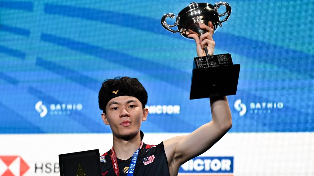 Malaysia's Lee Zii Jia poses on the podium with his trophy following his victory against Japan's Kodai Naraoka in their men's singles final match at the Australia Open badminton tournament in Sydney on June 16, 2024.
