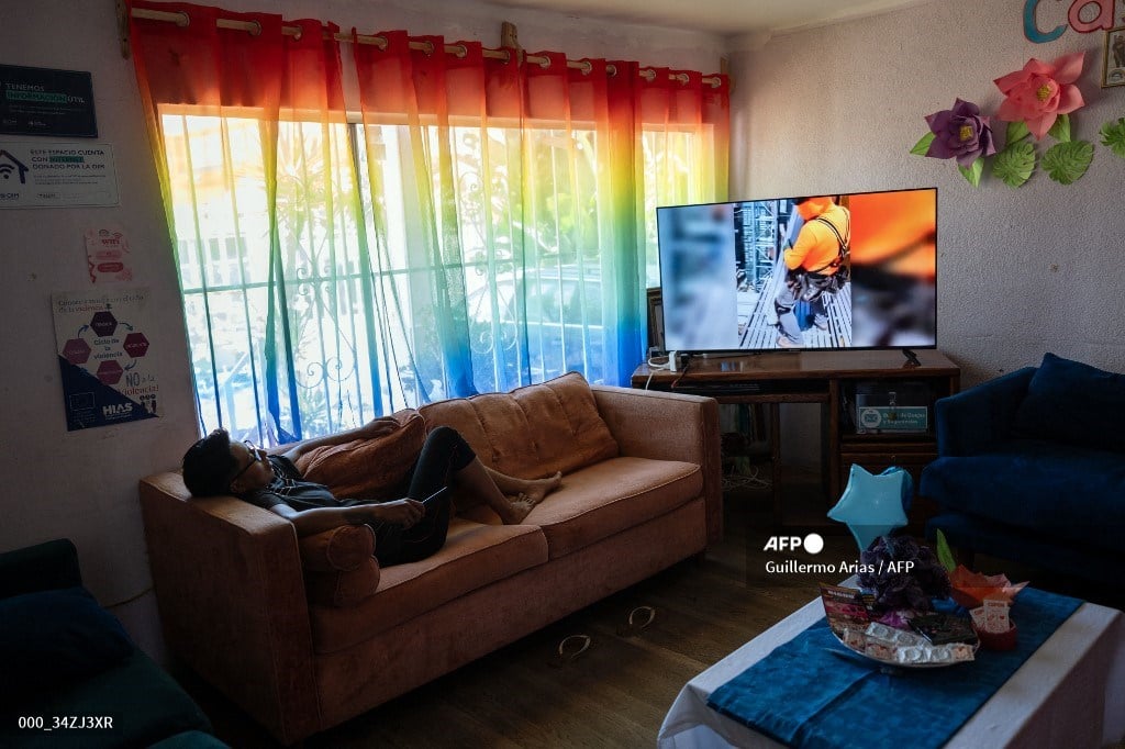 A migrant member of the LGBTQ community watches TV at Casa Arcoiris shelter in Tijuana, Baja California state, Mexico on June 26, 2024. LGBTQ migrants, considered among the most vulnerable of those seeking a better life in the United States, have found relief in Mexico in shelters specially set up to protect them from discrimination.