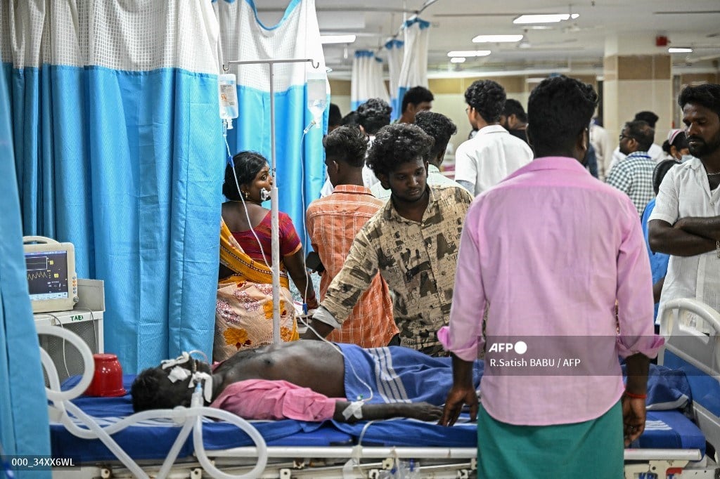Family members stand next to a patient admitted to a government hospital after consuming toxic alcohol in Kallakurichi district of India's Tamil Nadu state.