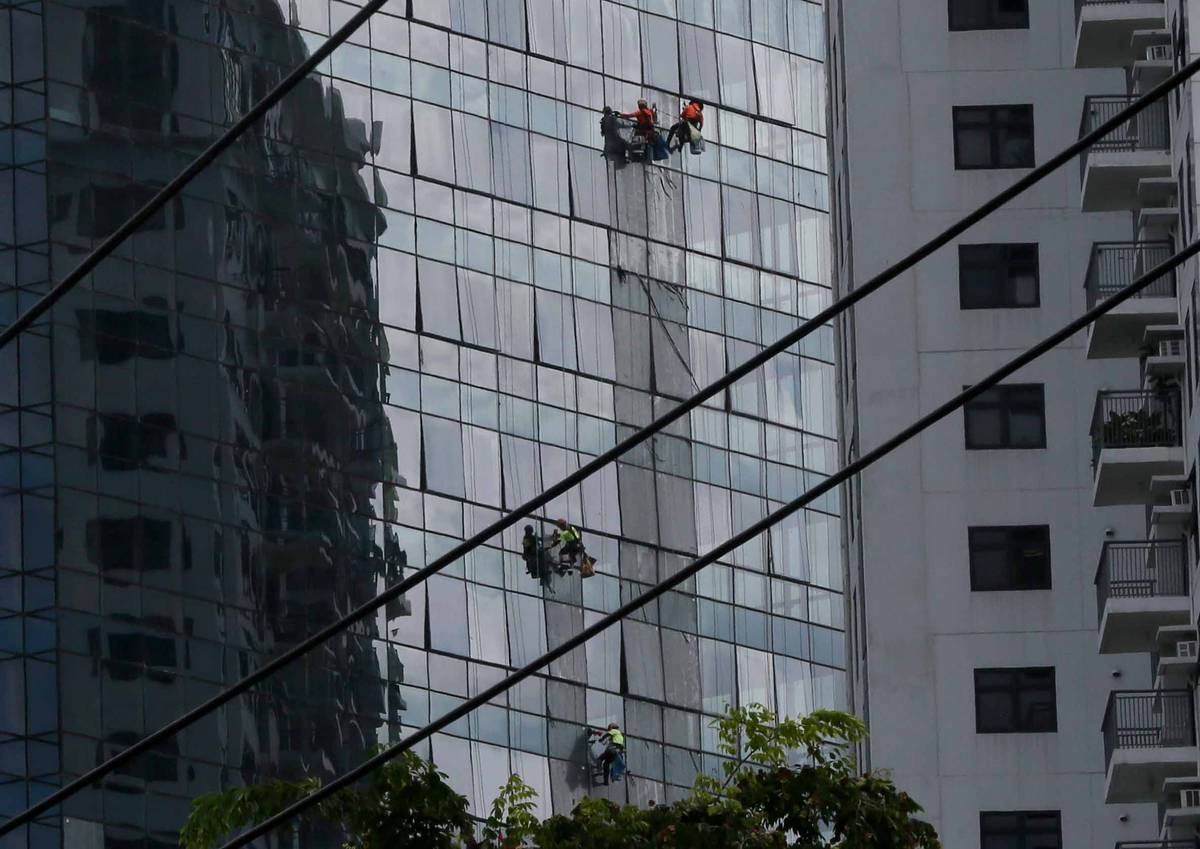 (June 28 2024)………Workers brave the staggering heights while cleaning the windows of a high-rise building in Quezon City on Friday, June 28 2024. President Ferdinand Marcos Jr. assures Filipinos that the current administration is exerting all its effort in addressing the issue of underemployment and unemployment issue in the country. According to a Labor Force Survey as of June 6, employed individuals in the country increased from 48.06 million last year to 48.46 million this year……….Photo/Analy Labor
