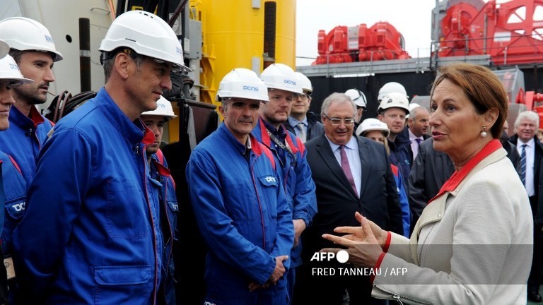 (FILES) French minister of Ecology Segolene Royale (R) speaks to French high-tech company DCNS workers, during a water turbine inauguration on 13 May 2016 in Brest, western of France. The water turbine is the second of the Paimpol-Brehat EDF parc set at sea off Brest harbor.