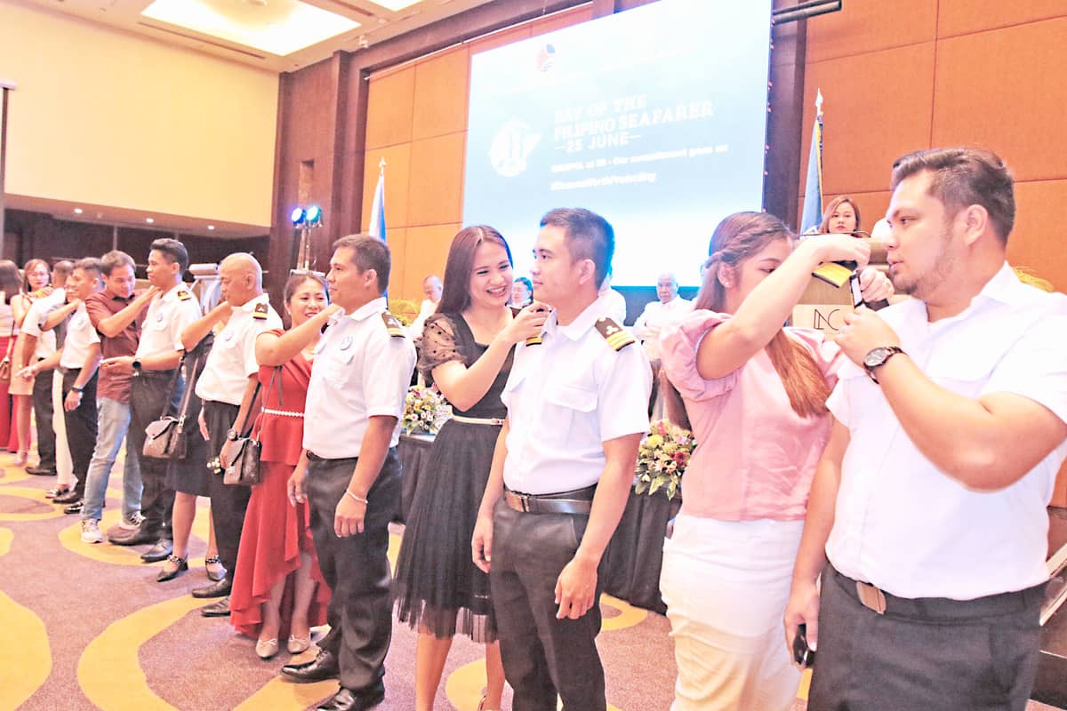 Parents and wives of seafarers who just recently passed the harbor pilot, marine deck and engineer officer conduct a donning of boards during a ceremony coinciding with the Day of the Filipino Seafarer 2023.