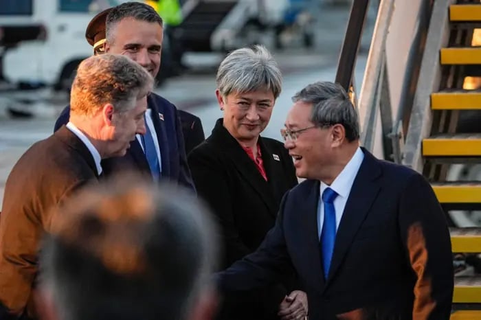China's Premier Li Qiang (right) greets Australia's Foreign Minister Penny Wong (centre), South Australia's Premier Peter Malinauskas (second lrft) and other officials at Adelaide Airport in Adelaide on June 15, 2024.