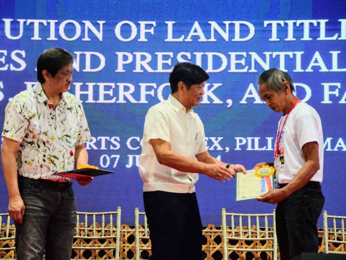 Alfredo Broña, agrarian reform beneficiary from Tabaco City, Albay receives his land title from President Ferdinand R. Marcos Jr. and DAR Secretary Conrado M. Estrella III.