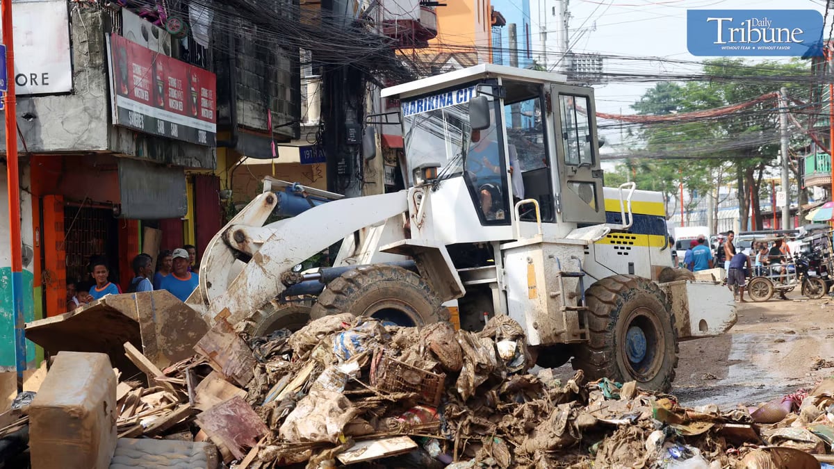 LOOK: Personnel from the Marikina Settlements Office-Homesite used pay-loaders to clean Kabayani Road in Marikina. The streets remained strewn with debris and trash days after the devastating floods caused by heavy rains from Super Typhoon Carina and the enhanced southwest monsoon (Habagat)
