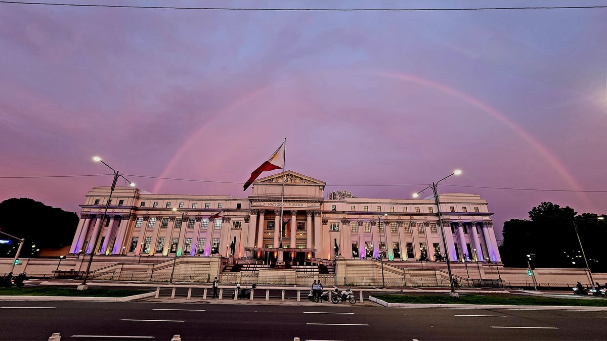 A rainbow appears over the National Museum of Fine Arts as the National Museum of the Philippines unfurls a Progress Pride Flag and lights the facade with rainbow colors.