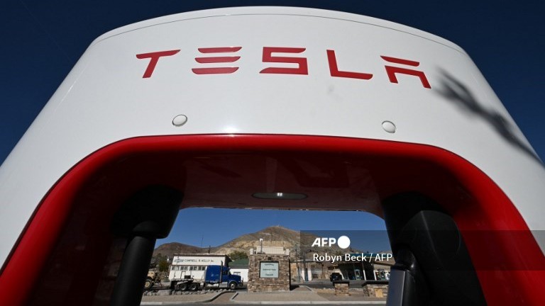 (FILES) A Tesla charger frames the site of the Tonopah Historic Mining Park, in the mining town of Tonopah, Nevada on May 8, 2024. Electric carmaker Tesla saw its shares surge on July 2, 2024, after reporting auto deliveries that beat analyst estimates, while General Motors logged slower second-quarter US sales. Tesla said it delivered around 444,000 vehicles worldwide in the April-June period, exceeding consensus estimates compiled by FactSet and sending its share price up around 9.0 percent.