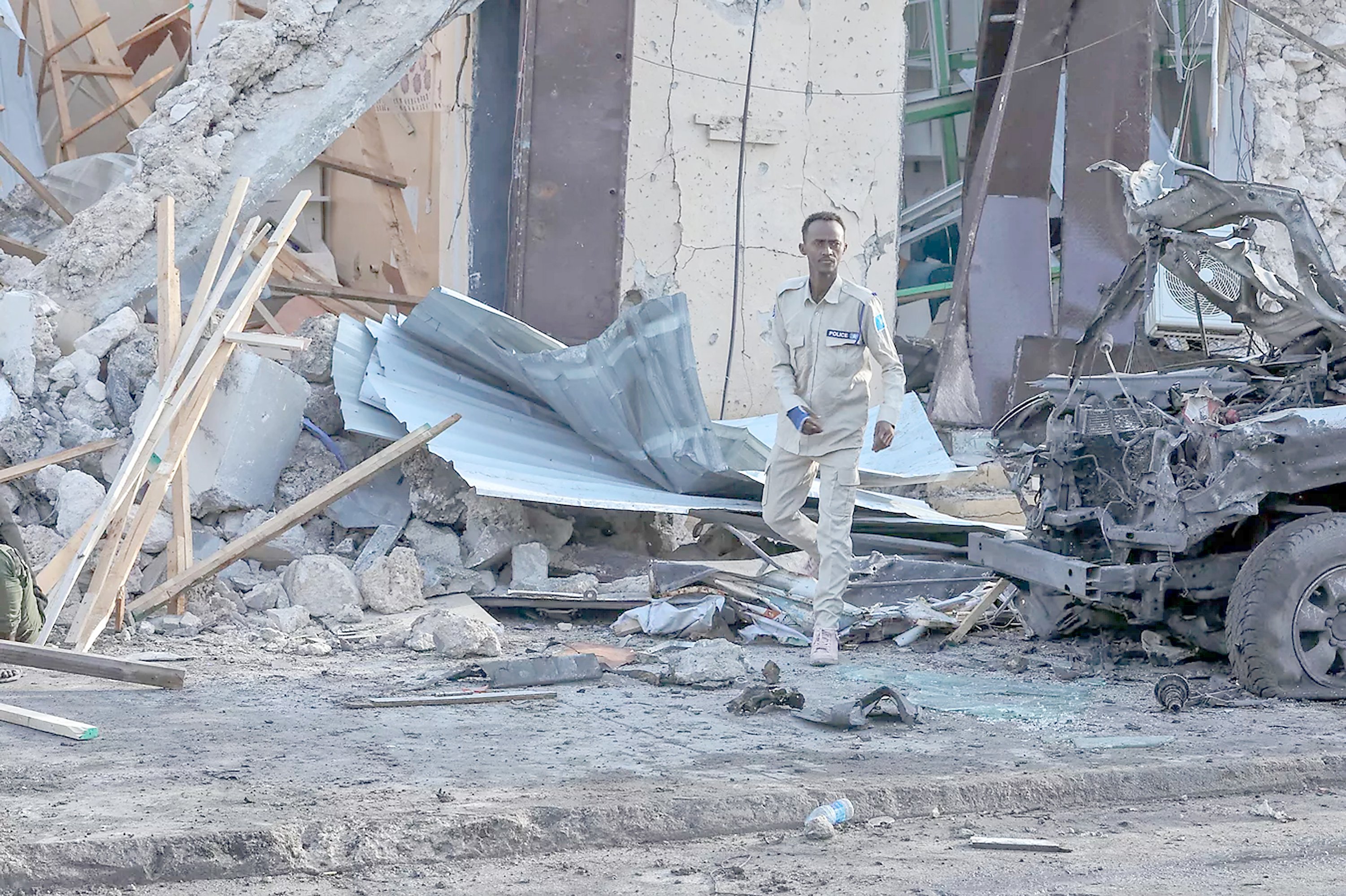 A Somalian police officer checks on the debris and destruction at a cafe in Mogadishu following a car bomb blast where five people were killed while watching the Euro 2024 final.