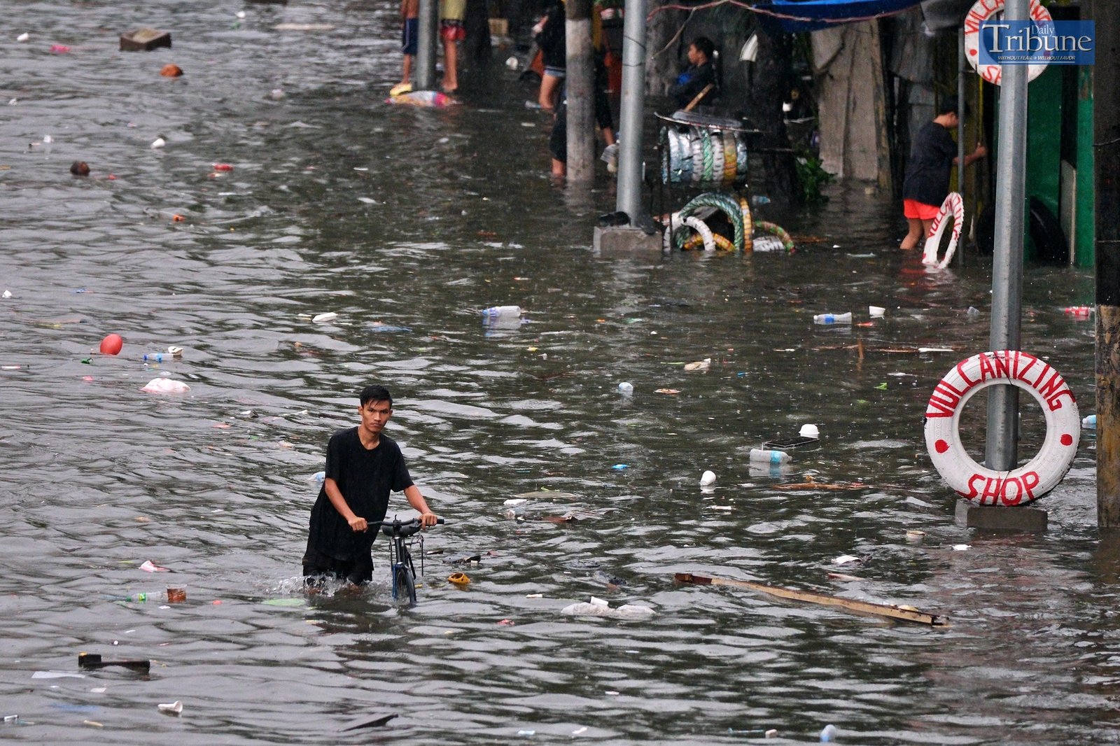 TRIBUNE-man-with-bike-on-flood