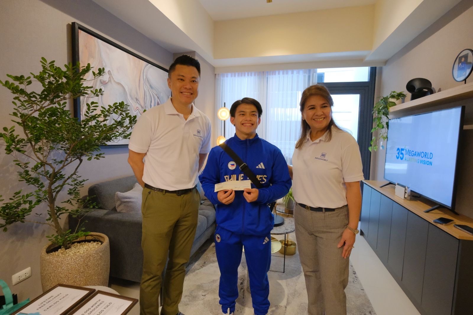 ‘Golden boy’ Carlos Yulo receives his P3-million cash bonus from property giant Megaworld, which is part of the company’s P35-million reward for the gymnast’s excellent performance at the 2024 Paris Olympic Games. On Wednesday, Yulo formally accepted the fully-furnished, three-bedroom condo unit at McKinley Hill in Taguig City from Kevin L. Tan, president and CEO, Alliance Global Group Inc., the parent company of Megaworld; and Lourdes T. Gutierrez-Alfonso, president, Megaworld Corporation.
