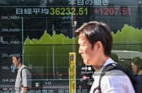 LOOK: A man is reflected in the display window of a brokerage showing the closing numbers of the Tokyo Stock Exchange, along a street in central Tokyo on August 13, 2024. Tokyo's key Nikkei index jumped 3.45 percent, or 1,207.51 points, on August 13 with sentiment boosted by a rally in US tech shares as traders returned from a long weekend break.| 📷 Richard A. Brooks / AFP
