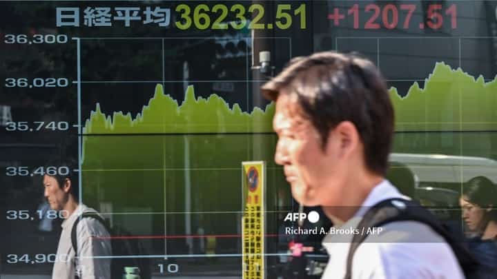 LOOK: A man is reflected in the display window of a brokerage showing the closing numbers of the Tokyo Stock Exchange, along a street in central Tokyo on August 13, 2024. Tokyo's key Nikkei index jumped 3.45 percent, or 1,207.51 points, on August 13 with sentiment boosted by a rally in US tech shares as traders returned from a long weekend break.| 📷 Richard A. Brooks / AFP