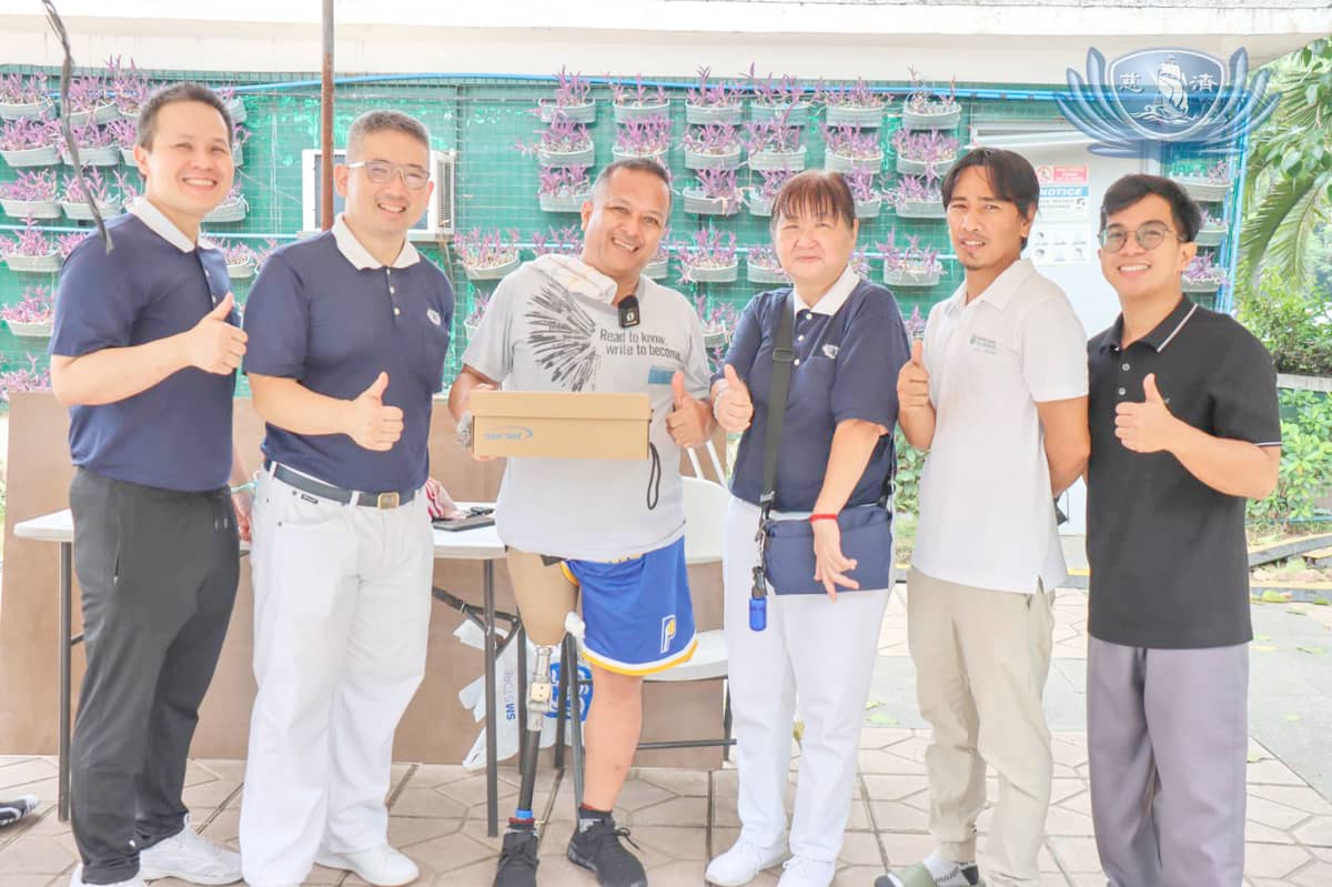 TIMOTEO Dicen wears a big smile after receiving his new prosthetic leg plus new shoes. Sharing his joy are volunteers from Tzu Chi Medical Foundation Philippines and Physicians for Peace-Philippines Walking Free Program which made his prosthetic.