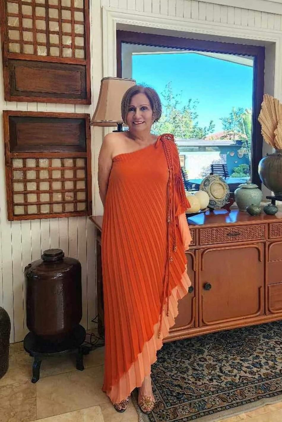 THE columnist in layered electric pleated asymmetric reversible dress in two tones of apricot.