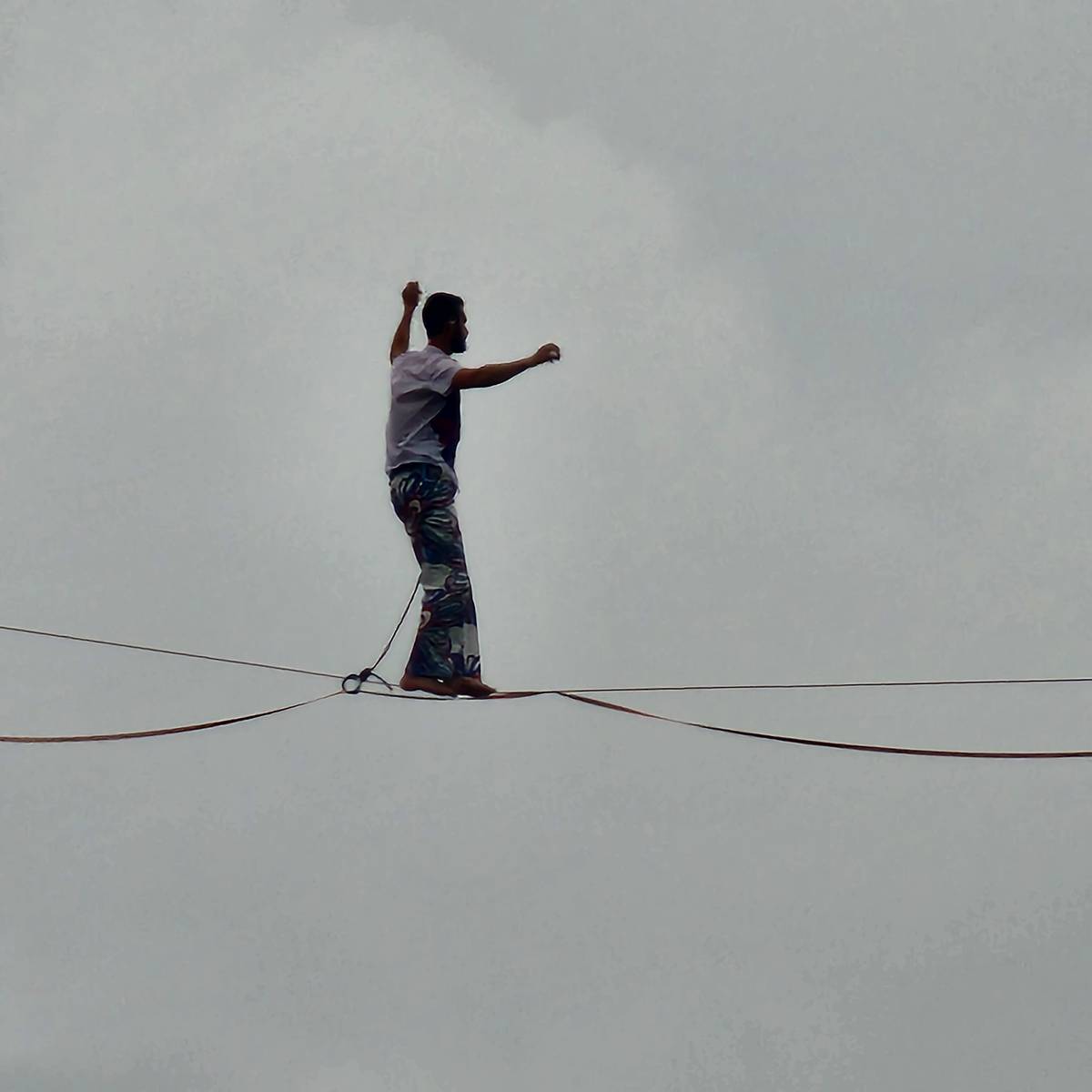 Suspended elegance: A tightrope walker balances above the River Seine in a moment of Olympic magic.
