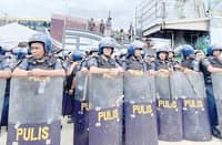 Anti-riot officers start barricading the main gate of the Kingdom of Jesus Christ compound in Davao City on Saturday, 24 August, as they serve the no-bail arrest warrant of its leader Pastor Apollo Quiboloy and his co-accused.