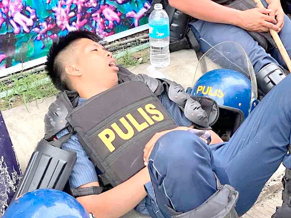 Anti-riot officers wait by the main gate of the Kingdom of Jesus Christ compound in Davao City on Saturday, 24 August, as they serve the no-bail arrest warrant of its leader Pastor Apollo Quiboloy and his co-accused.