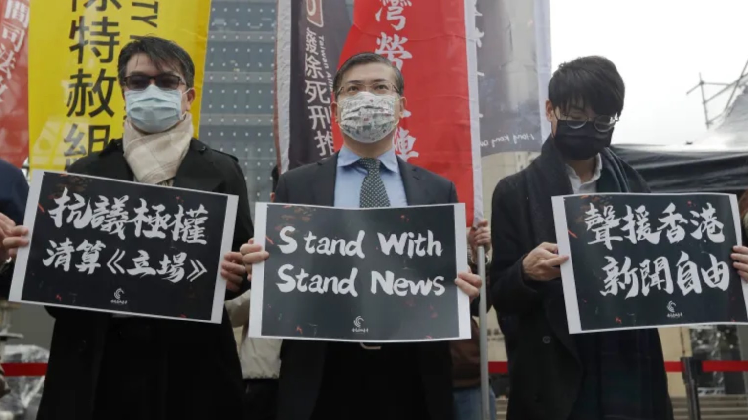 3 men holding pro-Stand News signs